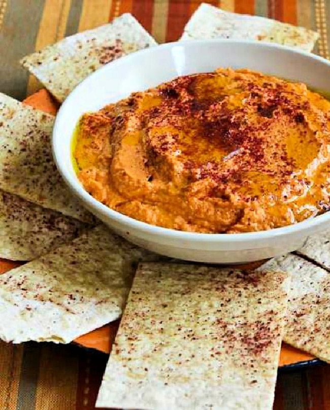 Roasted Tomato Hummus cropped image showing hummus in serving bowl with pita bread.