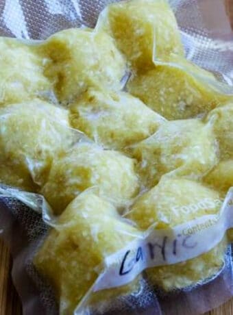 Freezing Garlic (Making Minced Garlic for the Freezer), photo of square photo of frozen minced garlic cubes sealed in bag.