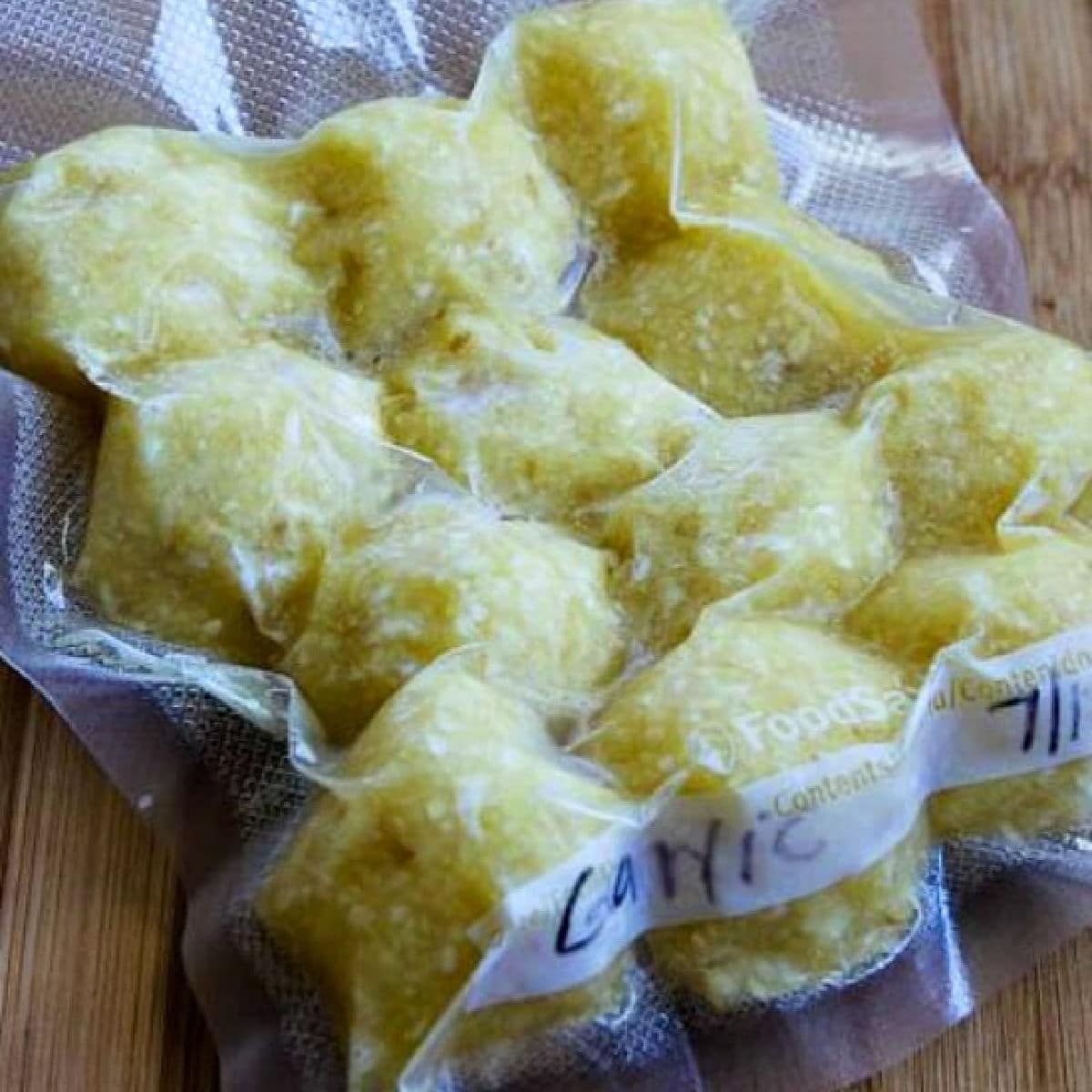 Freezing Garlic (Making Minced Garlic for the Freezer), photo of square photo of frozen minced garlic cubes sealed in bag.