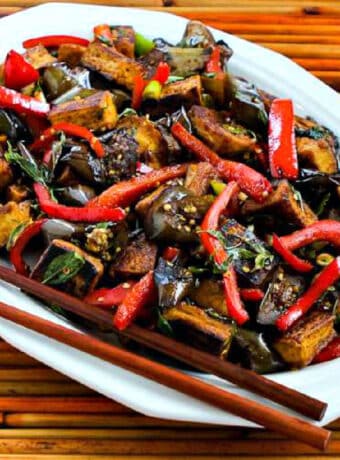 Stir-Fried Tofu with Eggplant, square image of tofu on serving plate with chopsticks.