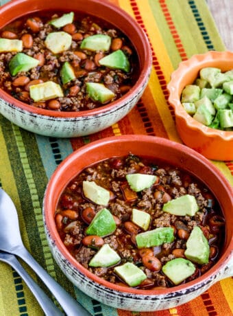 Instant Pot Pinto Beans with Ground Beef shown in two bowls with avocado