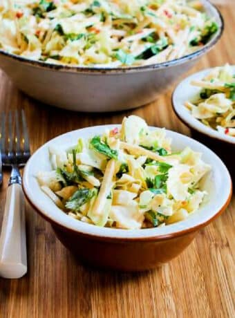 Square image of Apple Jicama Slaw in two bowls with serving bowl in back.