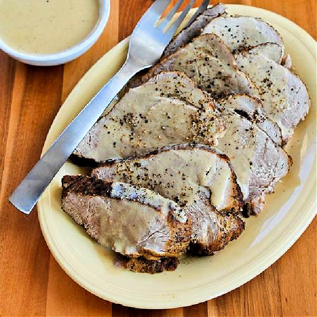 Slow Cooker Bavarian Pork Roast finished roast on serving plate with sour cream gravy