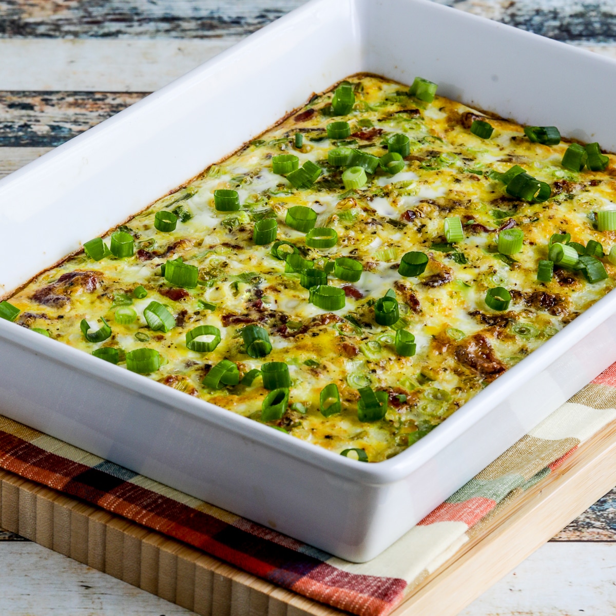 Square image of breakfast dish with feta bacon in a baking dish