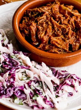 Low-Carb Slow Cooker Pulled Pork shown on plate with coleslaw