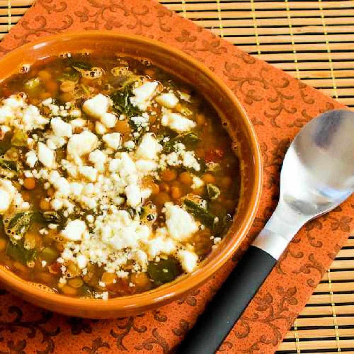 Square image of Slow Cooker Greek Lentil Soup in soup bowl, sprinkled with Feta.