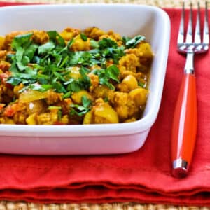 Turkey Curry with Chickpeas shown in square serving bowl on red napkin.