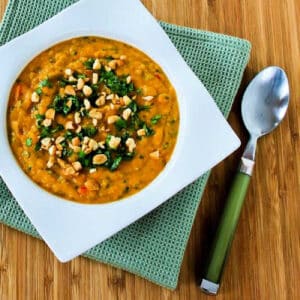 Square image for Slow Cooker Butternut Squash Soup shown in square bowl with napkin and spoon.