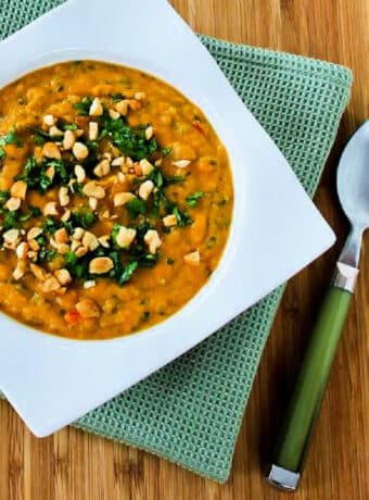 Square image for Slow Cooker Butternut Squash Soup shown in square bowl with napkin and spoon.