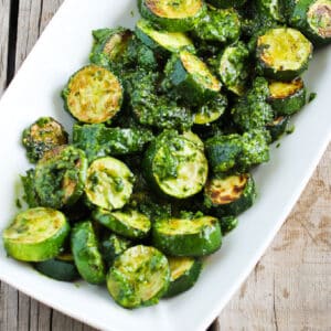 Zucchini with Pesto on serving platter sitting on wooden table