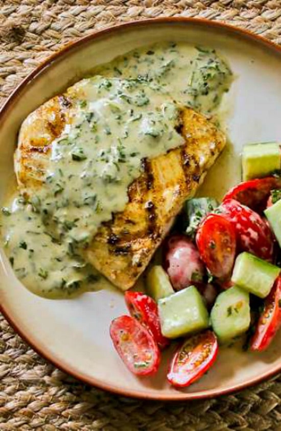 Grilled Halibut with Basil Vinaigrette cooked fish on plate with tomato-cucumber salad