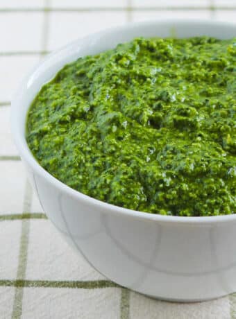 square image of Spinach and Basil Pesto in white bowl