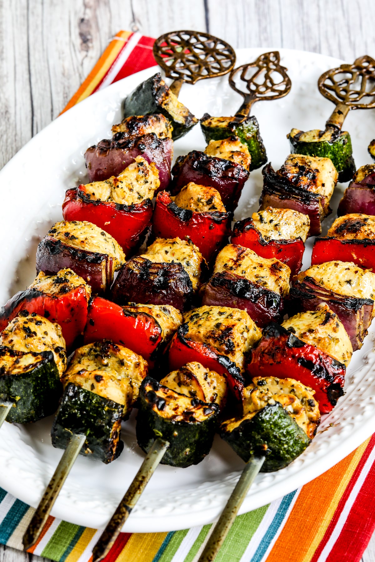 Grilled Chicken Kabobs with Vegetables shown on serving platter on striped napkin.