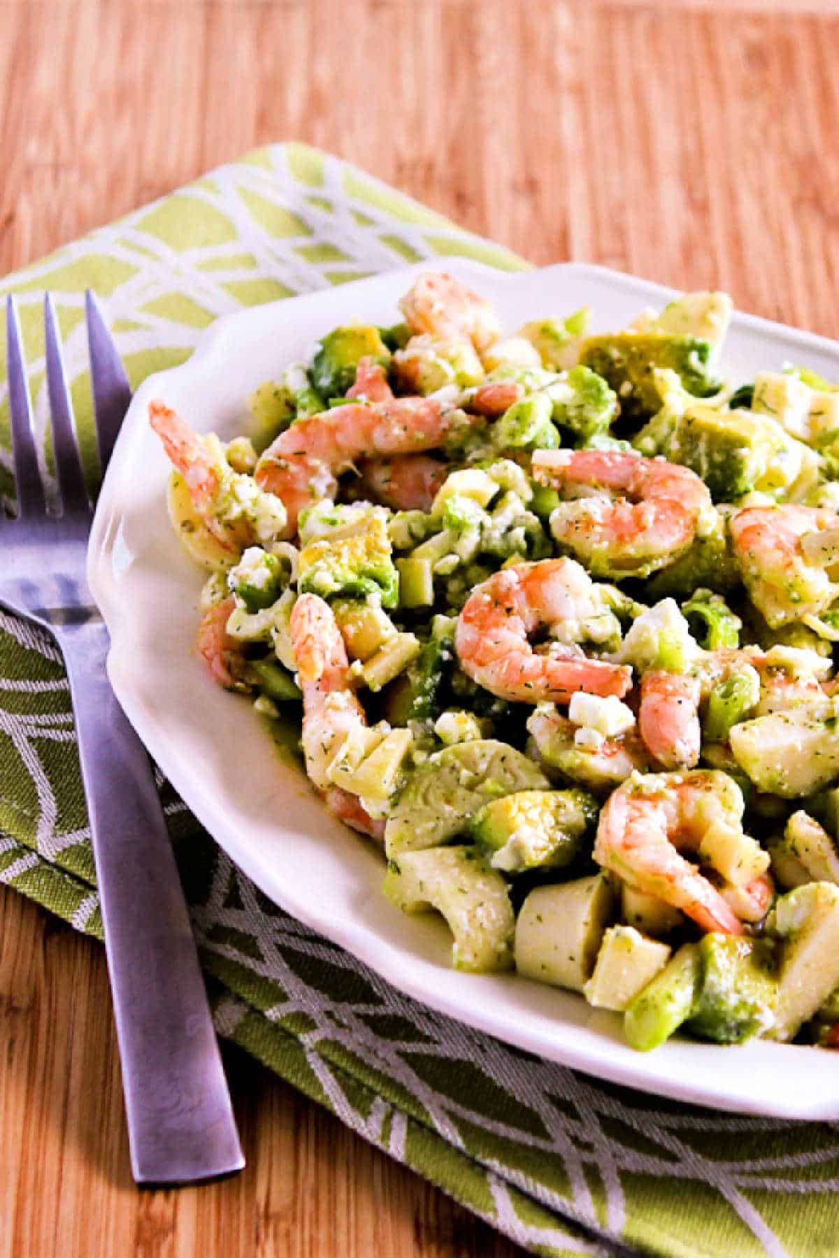 shrimp salad in serving bowl with green napkin and fork