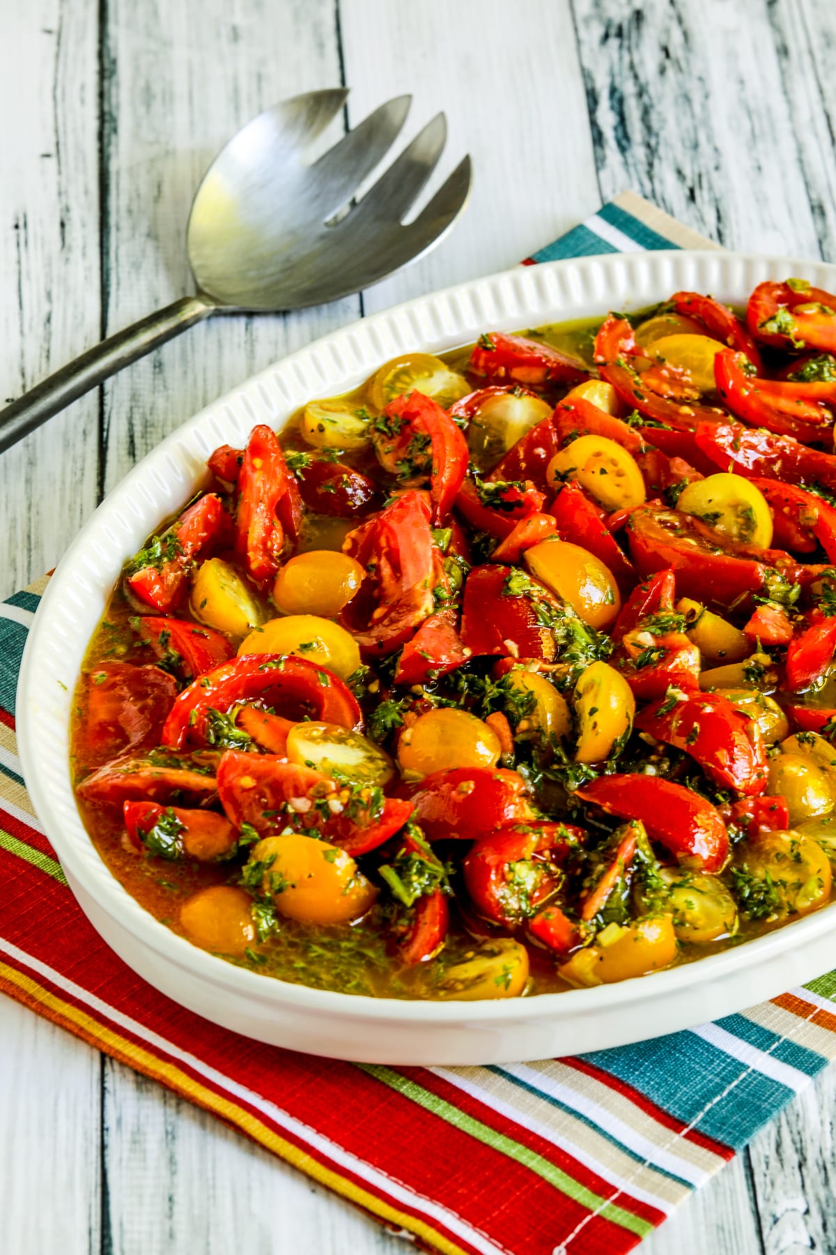 Marinated Tomatoes with Herb Dressing shown in serving dish with fork