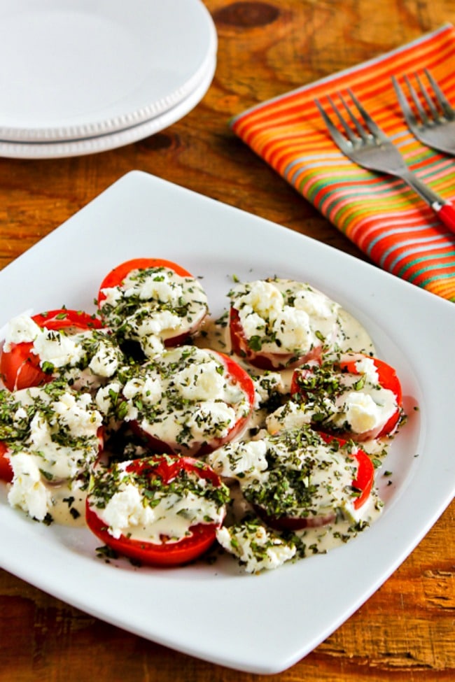 Summer Tomato Salad with Goat Cheese, Basil Vinaigrette, and Herbs close-up photo of finished salad on plate