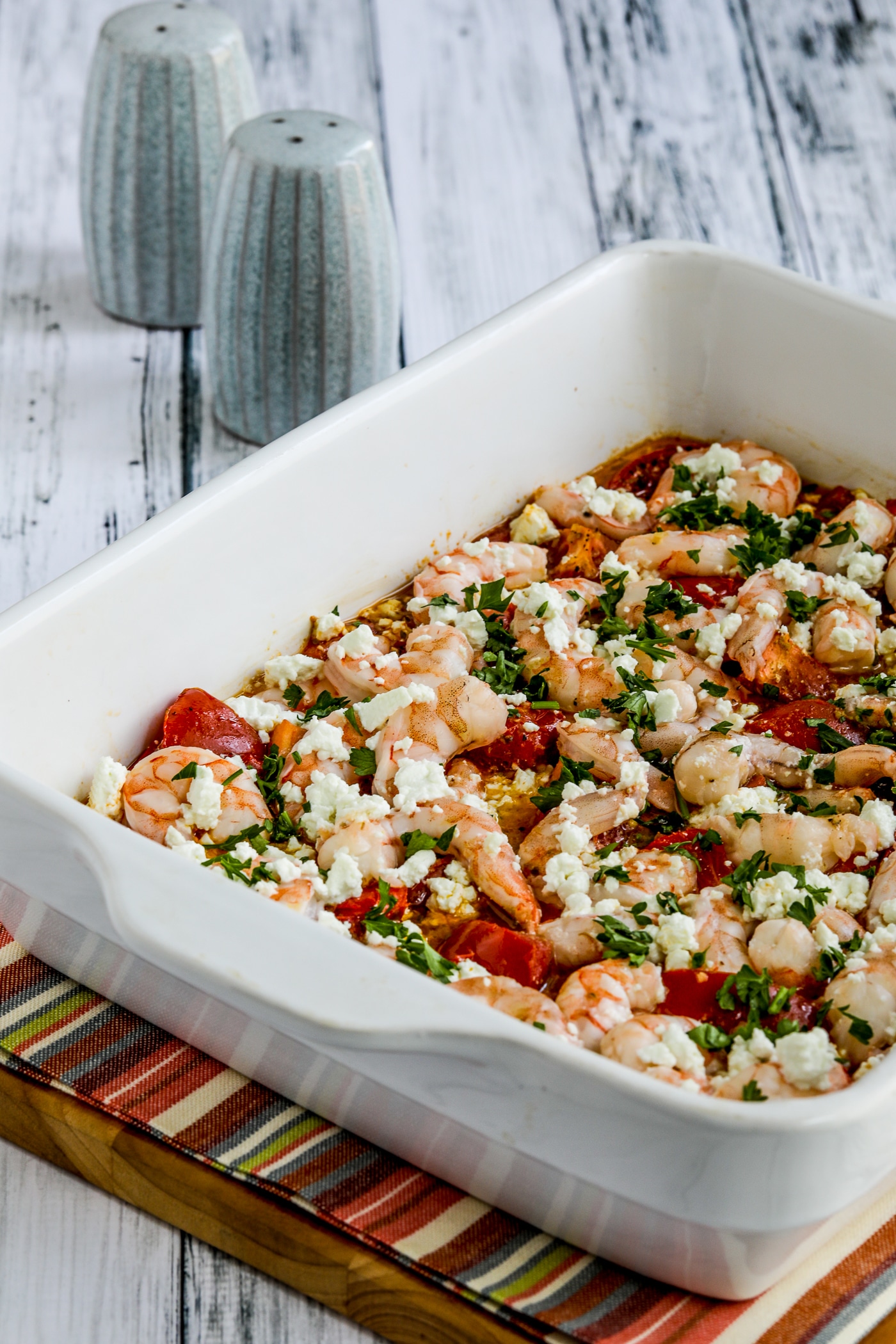Roasted tomatoes and prawns with feta shown in a serving dish after cooking