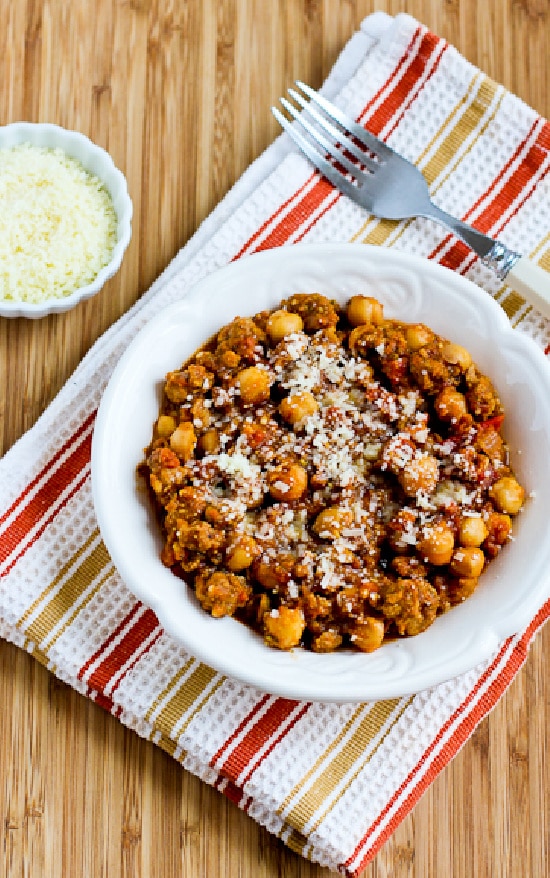 Sausage and Chickpea Stew in serving bowl with Parmesan on the side