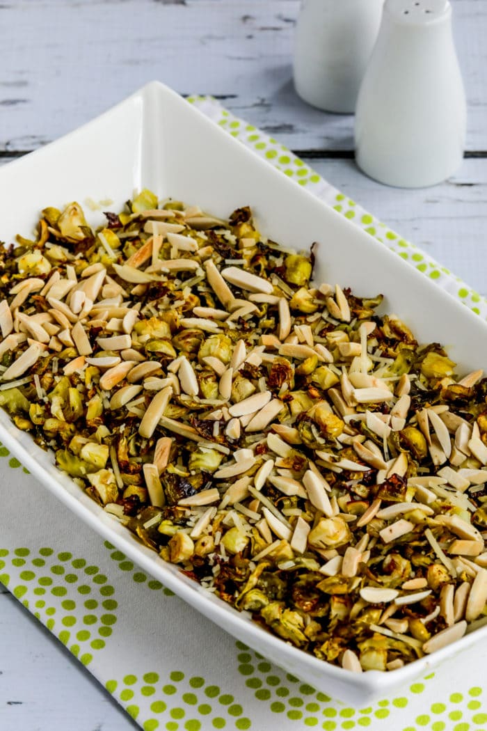 Roasted Shredded Brussels Sprouts in serving dish with salt pepper in background