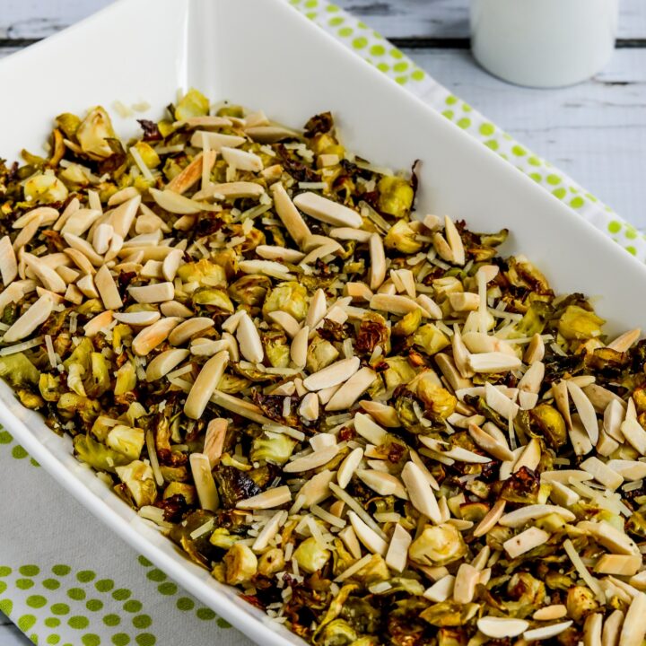 Roasted Shredded Brussels Sprouts in serving dish with salt pepper in background