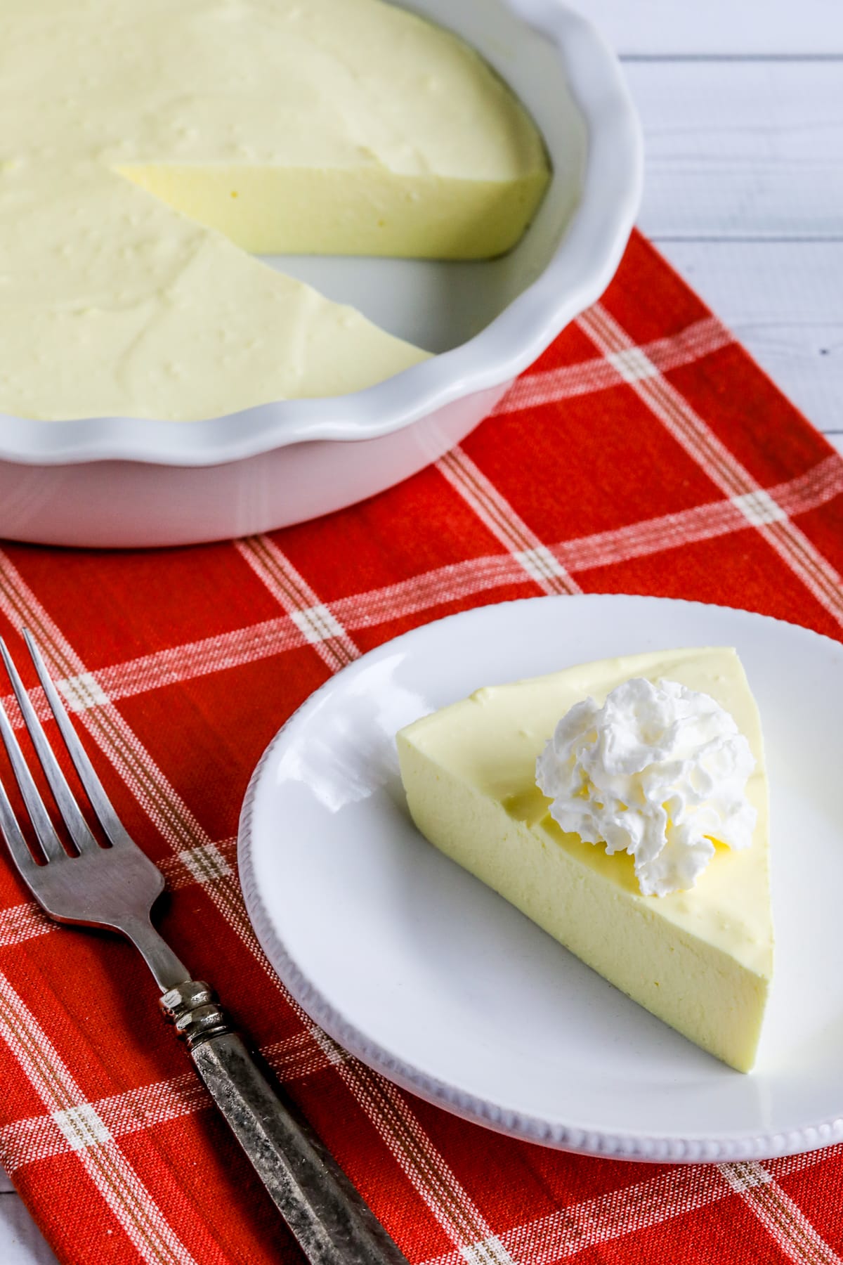 Sugar-Free Jello Yogurt Pie with one piece on plate and cut pie in background.