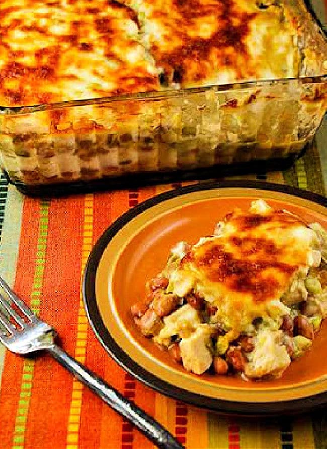 Mexican Chicken Casserole with Pinto Beans with one serving on plate and casserole in back.