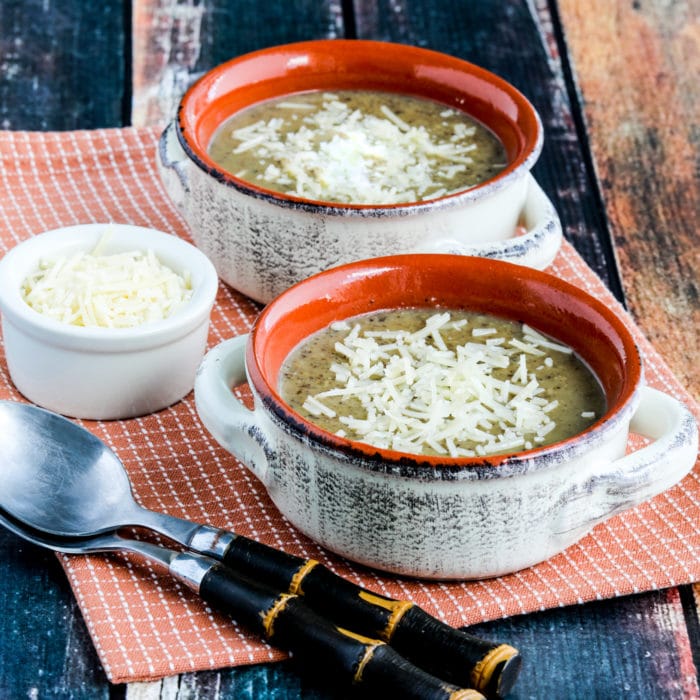 square image of Instant Pot Cauliflower Mushroom Soup shown in two serving bowls with Parmesan cheese