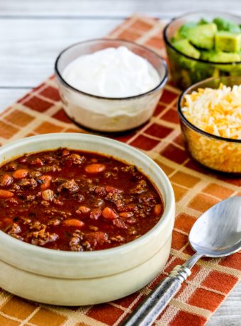 Easy Taco Soup bowl of soup with sour cream, avocado, and grated cheese on the side