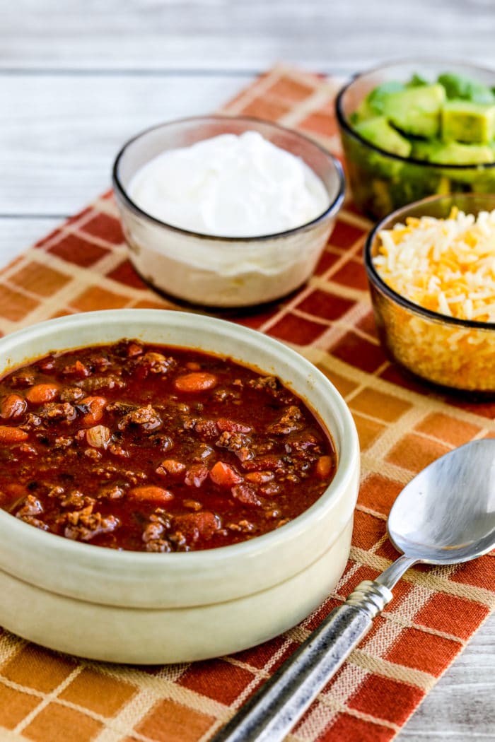 Easy Taco Soup bowl of soup with sour cream, avocado, and grated cheese on the side