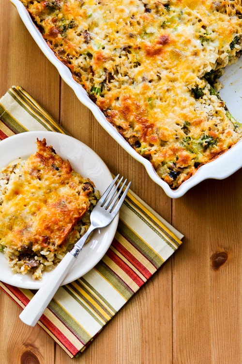 Cheesy Vegetarian Casserole shown with one serving on plate and casserole in serving dish
