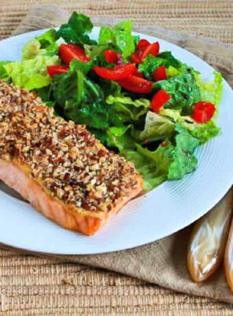 Square image of Pecan Crusted Salmon shown on serving plate with salad.