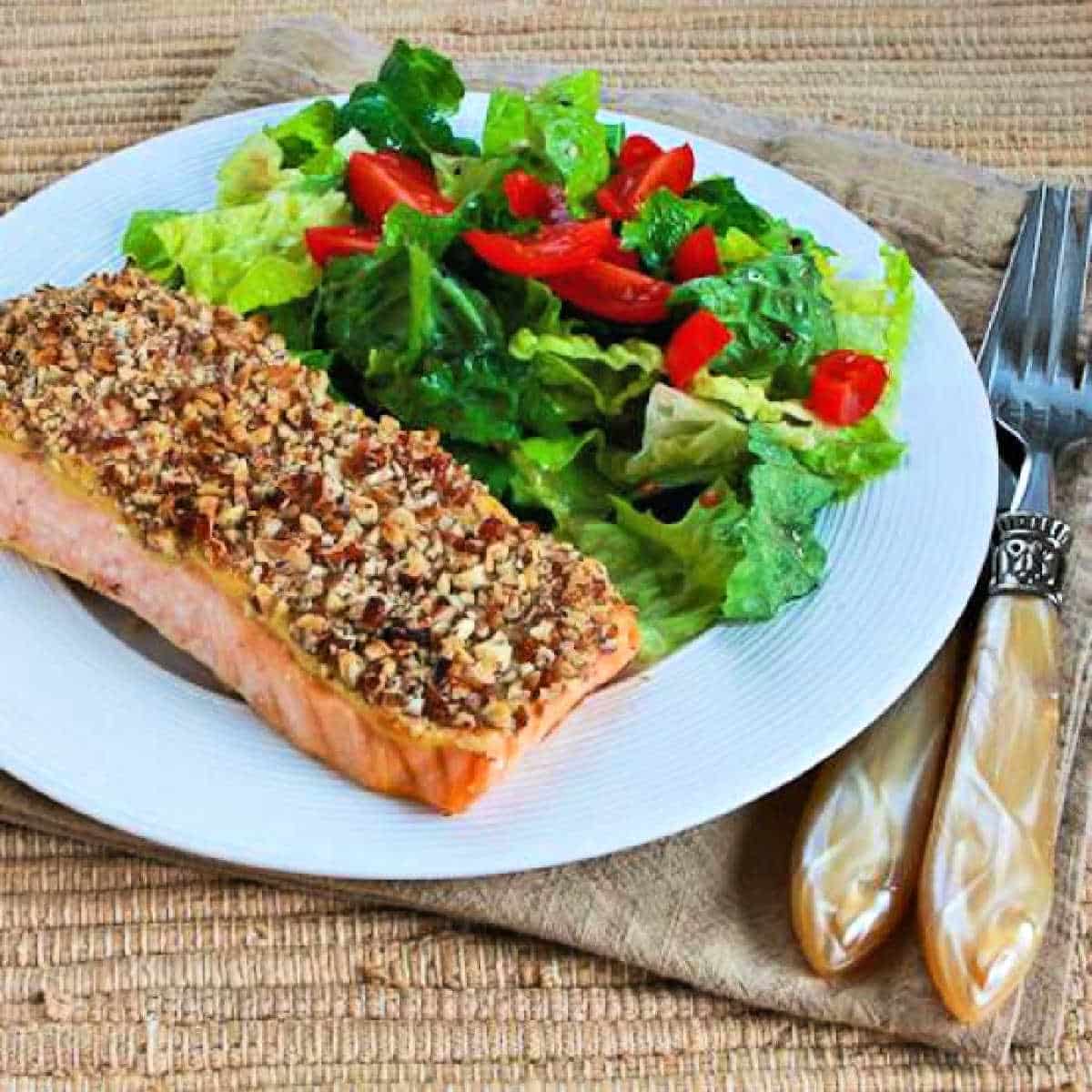 Square image of Pecan Crusted Salmon shown on serving plate with salad.