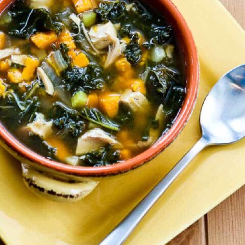 Slow Cooker Turkey Soup with Kale and Sweet Potatoes with soup in bowl on yellow plate