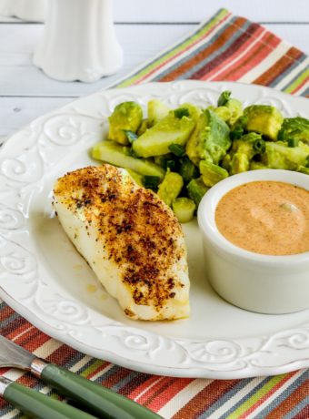 Spicy Air Fryer Fish shown on plate with avocado salad and remoulade sauce