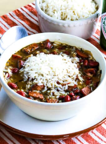 Red Beans and Rice Soup shown in bowl with spoon and Green Tabasco Sauce in back.
