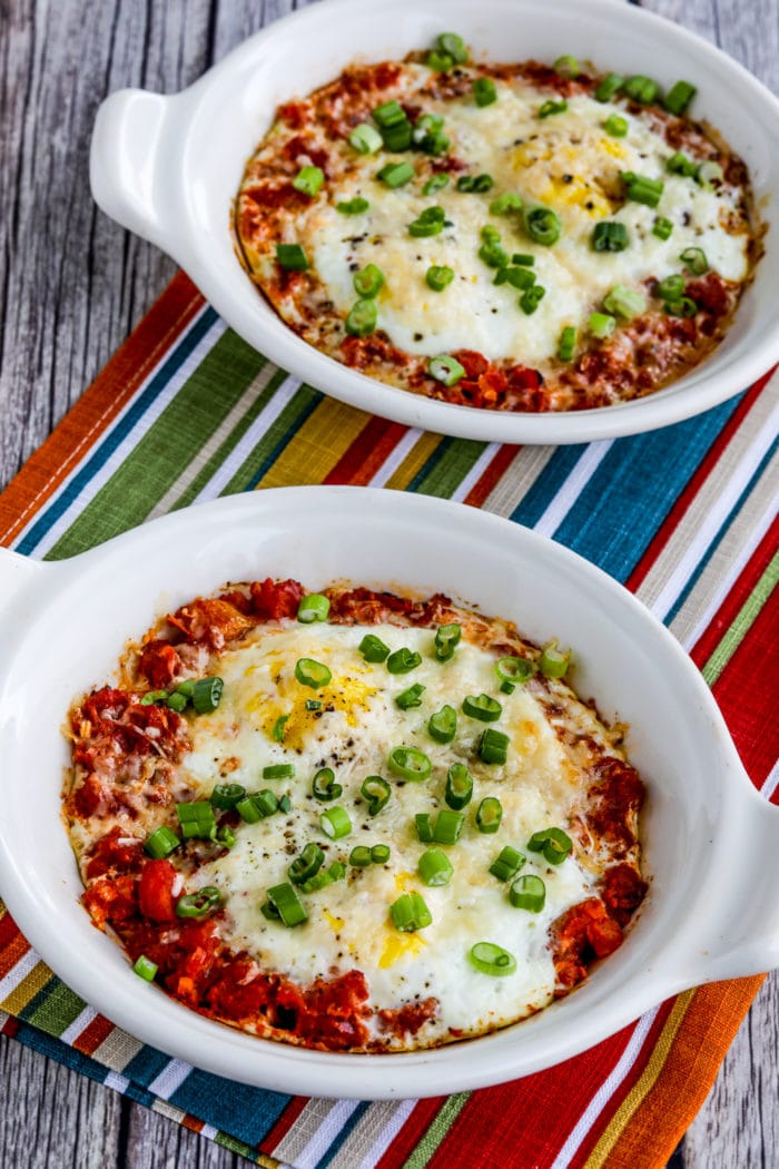 Close-up photo of Tuscan Baked Eggs with Tomatoes finished eggs in baking dishes