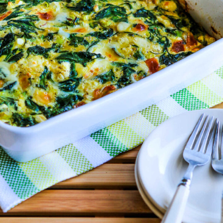 Power Greens Breakfast Casserole in baking dish with plates-forks in front