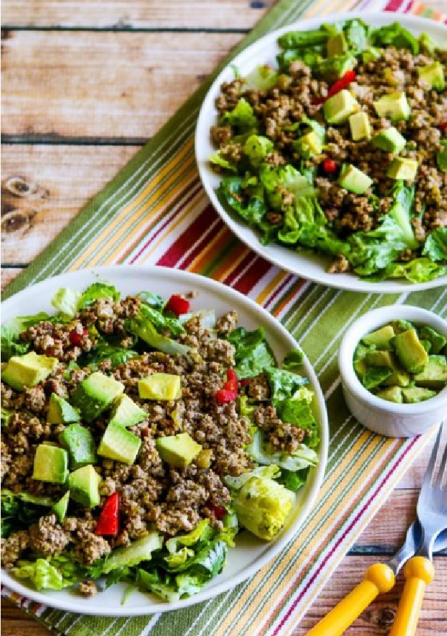 Green Chile Turkey Taco Salad shown in two serving bowls with avocado on the side