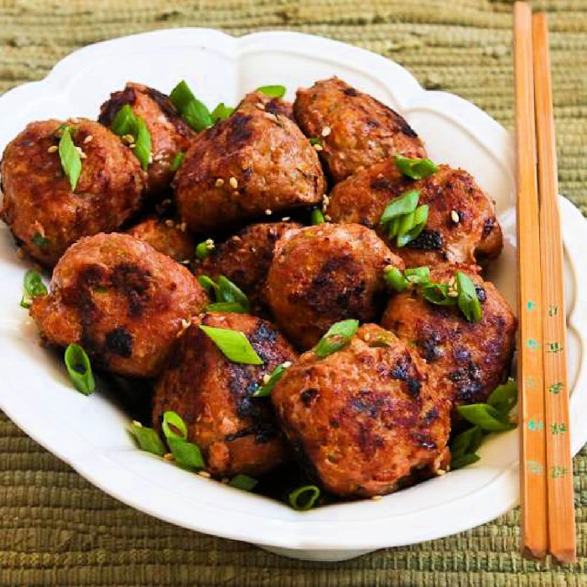 Grilled Sriracha Turkey Meatballs shown on serving plate with chopsticks.