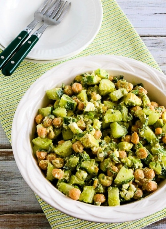 Cucumber Avocado Salad with Chickpeas and Feta in serving bowl with plates and forks