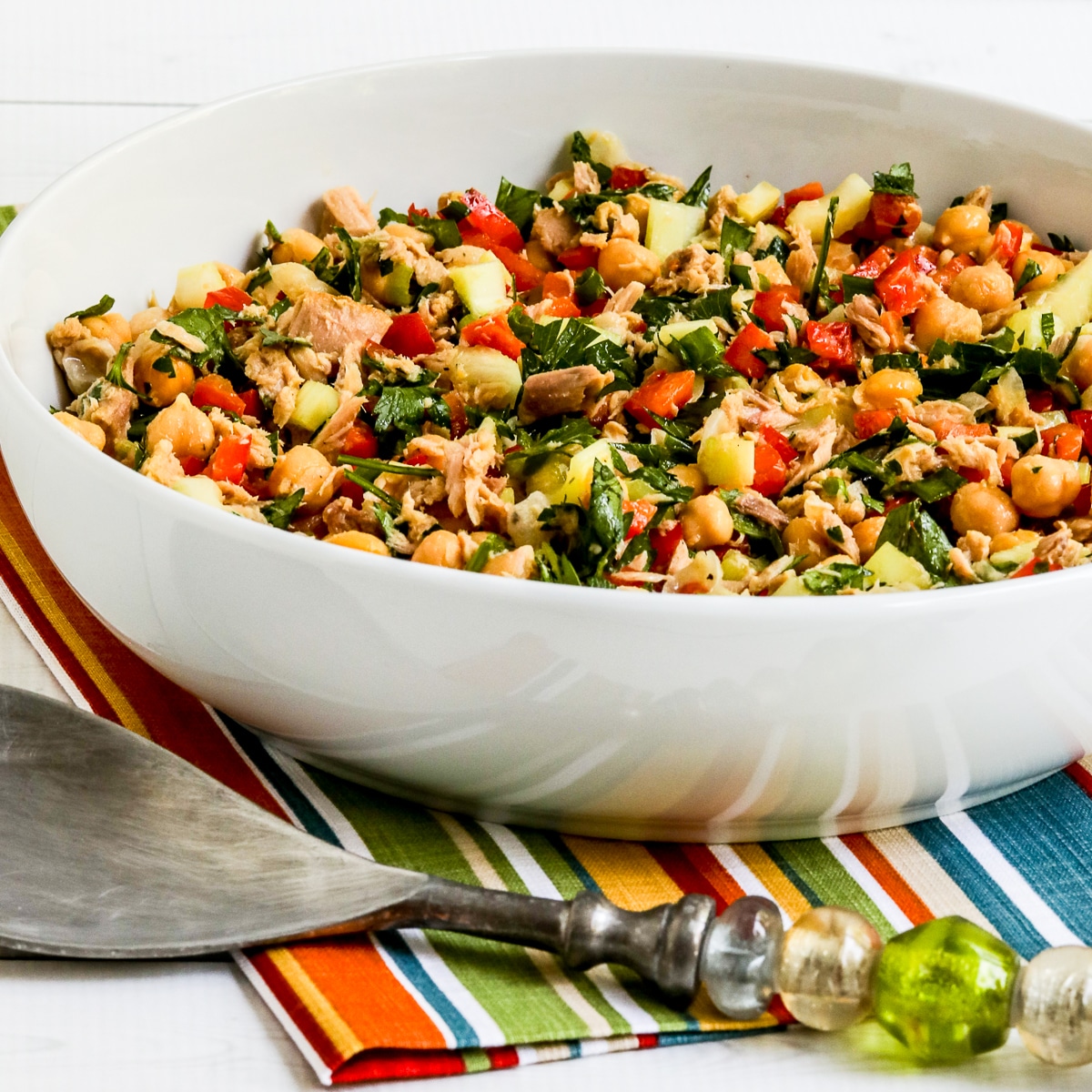 Chickpea Tuna Salad in white serving bowl on striped napkin.