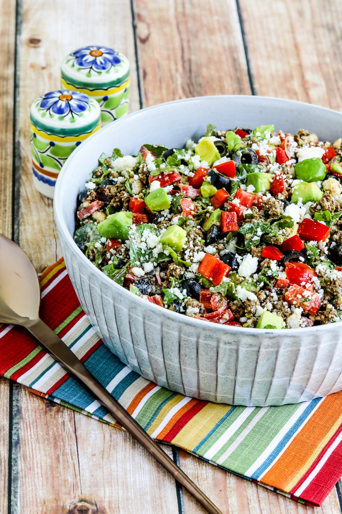 Ground beef taco salad with kale, tomato, and avocado as shown in serving bowl.