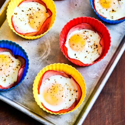 Baked Eggs in Canadian Bacon Cups finished eggs on baking sheet