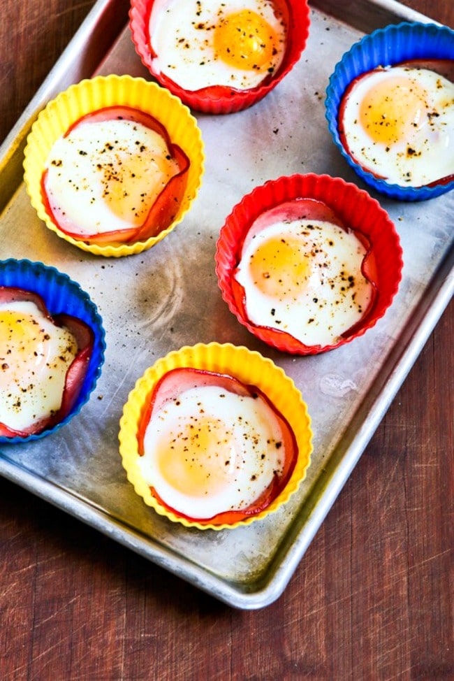 Baked Eggs in Canadian Bacon Cups finished eggs on baking sheet