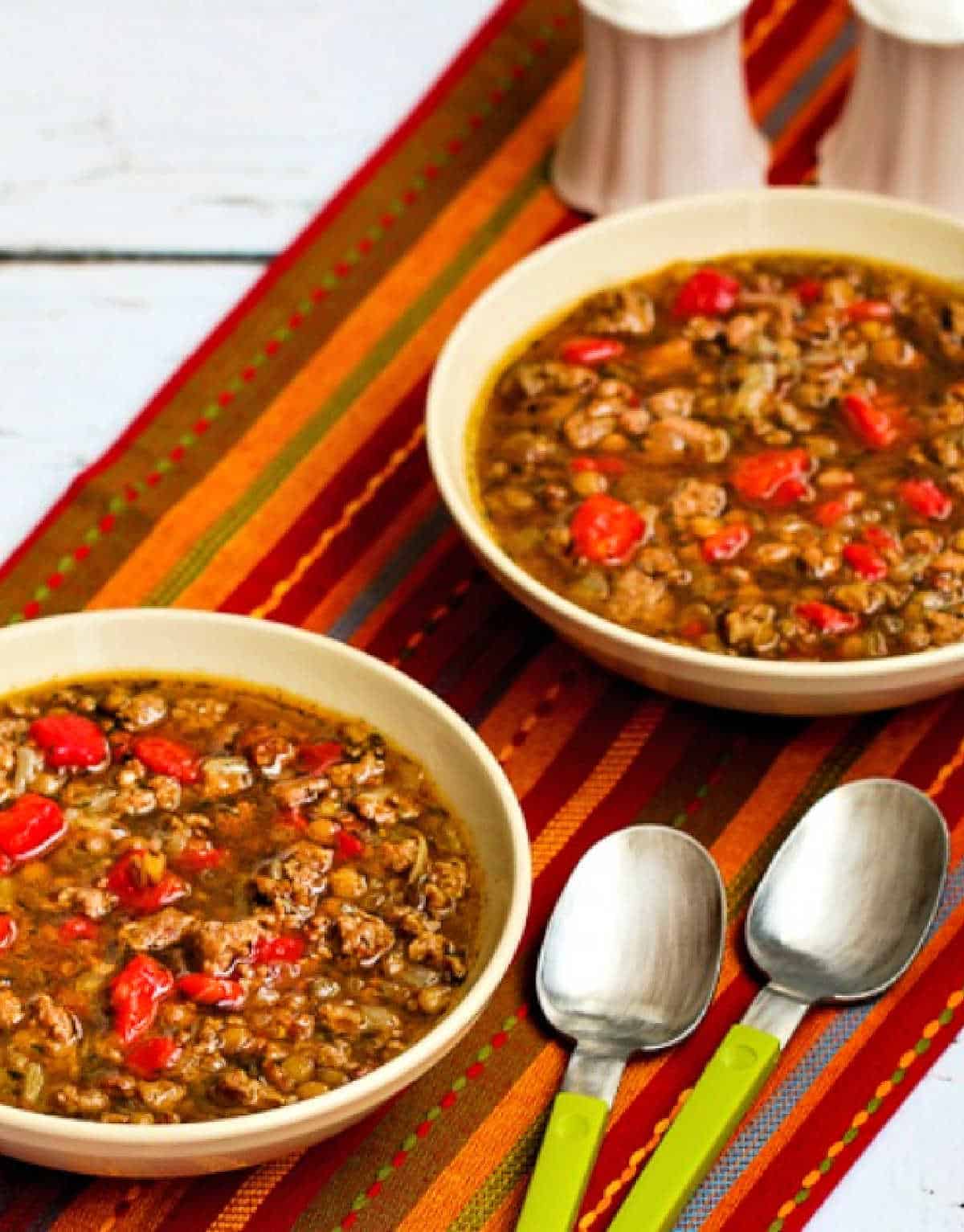 cropped image of Sausage and Lentil Soup with soup in two bowls on napkin