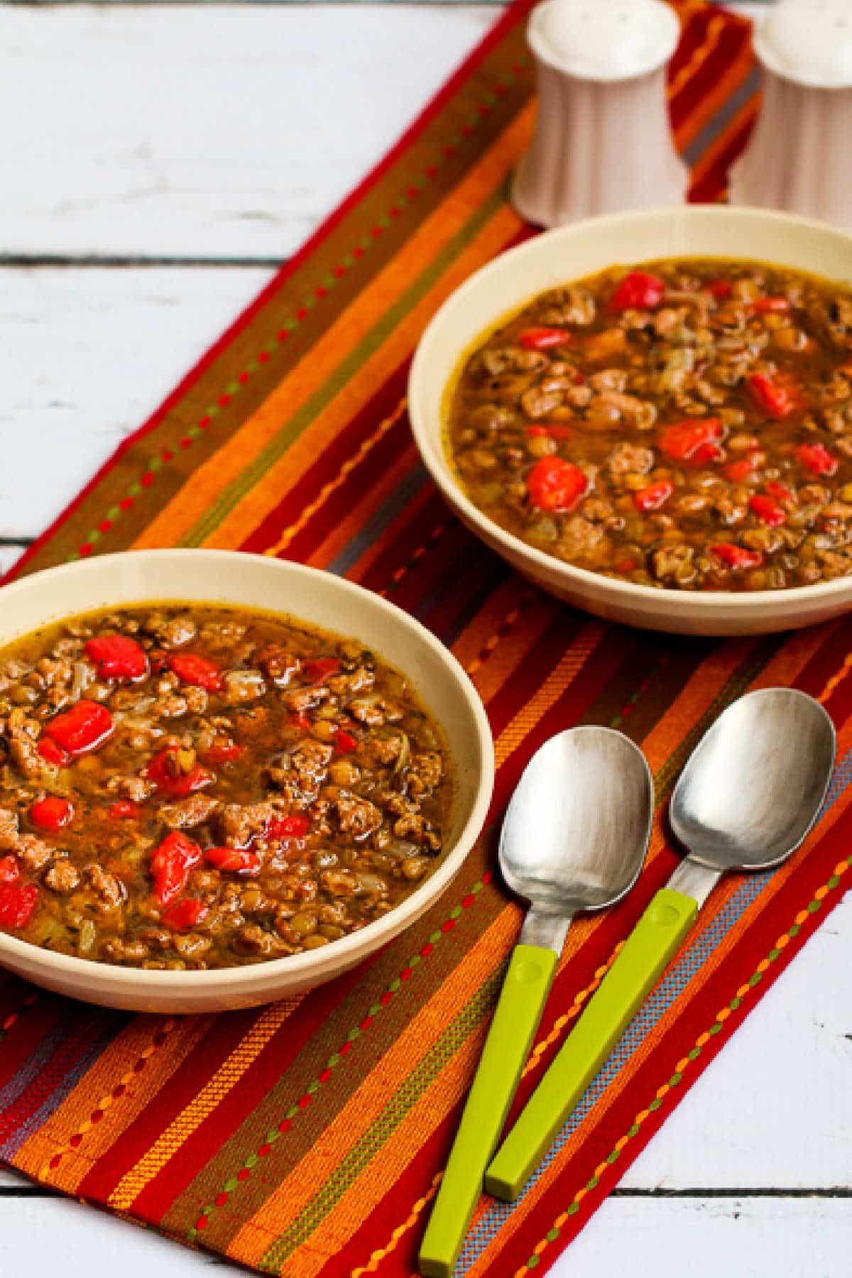 Sausage and Lentil Soup shown in two serving bowls on red napkin