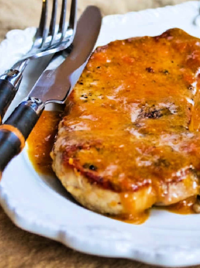 Apricot Glazed Pork chops shown on serving plate with knife-fork.