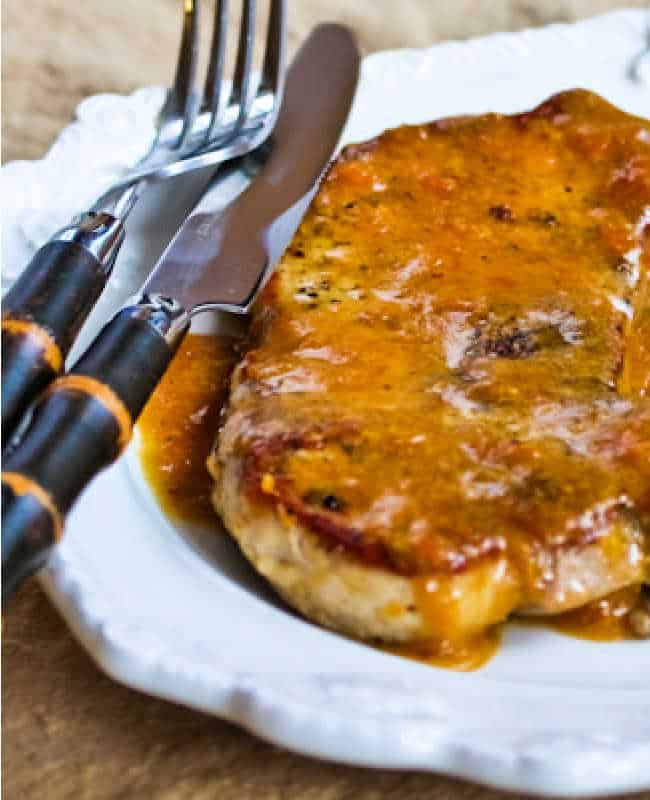 Pork Chops with Apricot Sauce shown on plate with knive and fork