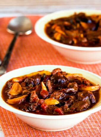 Square image of Garlic Lover's CrockPot Beef Stew in two bowls on red napkin.