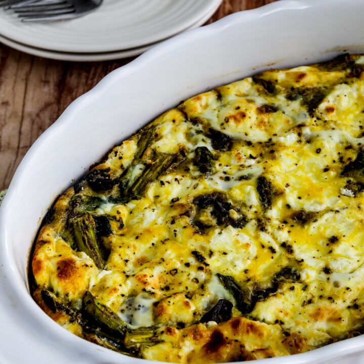 Asparagus, Mushroom, and Goat Cheese Breakfast Casserole shown in baking dish with plates, forks, and napkin